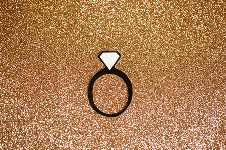 fake paper party engagement ring with gold glitter backdropの写真素材