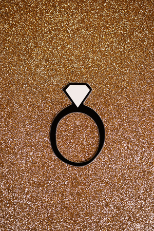 fake paper party engagement ring with gold glitter backdropの写真素材