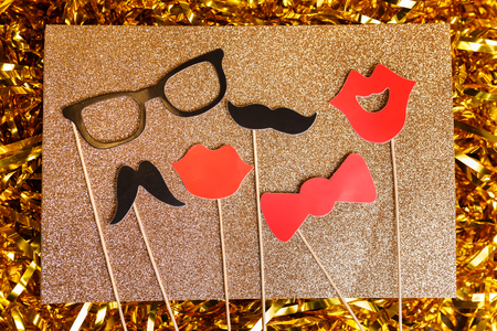 Paper accessories for holidays, birthday, parties, carnival and wedding celebration concept. Accessories for photobooths photoshooting on golden glitter background.の写真素材