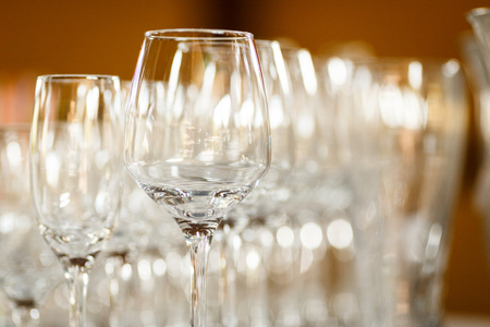 Empty glasses for wine and champagne in a row at the banquet tableの写真素材