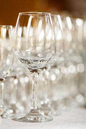 Empty glasses for wine and champagne in a row at the banquet tableの写真素材