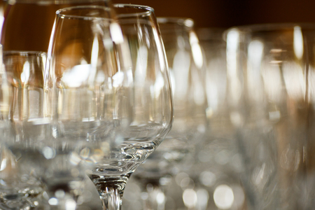 Empty glasses for wine and champagne in a row at the banquet tableの写真素材