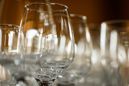 Empty glasses for wine and champagne in a row at the banquet tableの写真素材