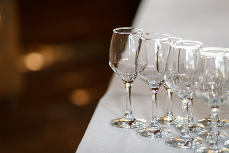 Empty glasses for wine and champagne in a row at the banquet tableの写真素材