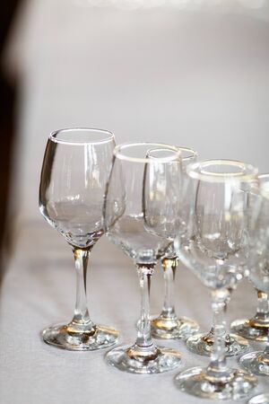 Empty glasses for wine and champagne in a row at the banquet tableの写真素材