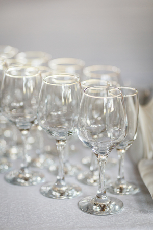 Empty glasses for wine and champagne in a row at the banquet tableの写真素材