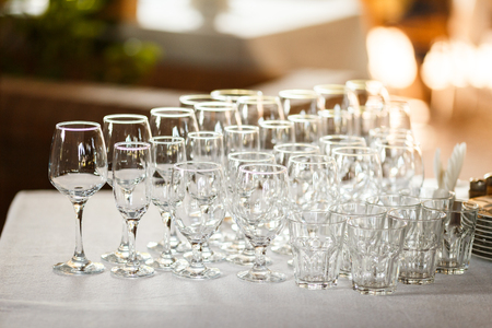 Empty glasses for wine and champagne in a row at the banquet tableの写真素材
