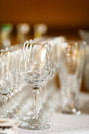 Empty glasses for wine and champagne in a row at the banquet tableの写真素材