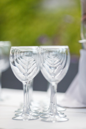 Empty glasses for wine and champagne in a row at the banquetの写真素材