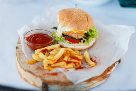 Tasty chicken burger with fresh fries. Concept of fast food.の写真素材