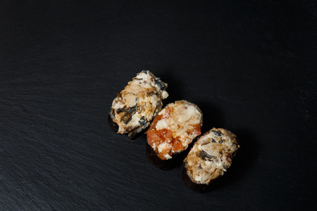 Gunkan Maki Sushi with with salmon on a black stone slate. Sushi menu. Japanese food. Trend color 2019 coral. Background image.の写真素材