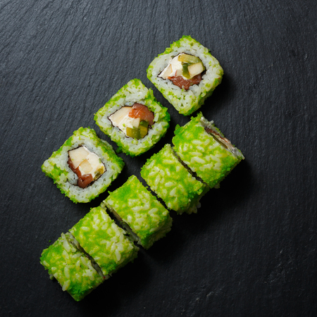Japanese sushi rolls served on stone slate on dark background. Sushi background. Asian or Japanese food.の写真素材