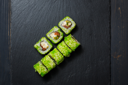 Japanese sushi rolls served on stone slate on dark background. Sushi background. Asian or Japanese food.の写真素材