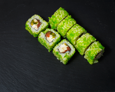Japanese sushi rolls served on stone slate on dark background. Sushi background. Asian or Japanese food.の写真素材