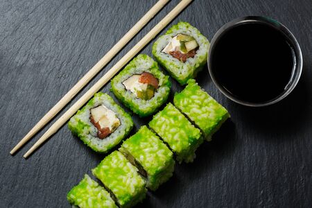 Japanese sushi rolls with soy sauce served on stone slate on darkの写真素材