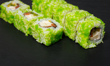 Japanese sushi rolls served on stone slate on dark background. Sushi background. Asian or Japanese food.の写真素材