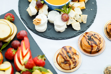 Cheese plate served with fruit and honeyの写真素材
