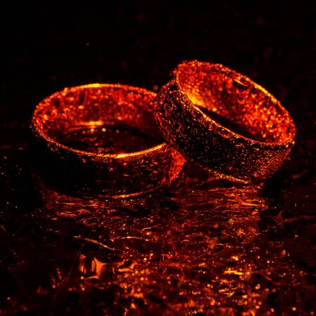 Beautiful gold wedding rings with water dropsの写真素材