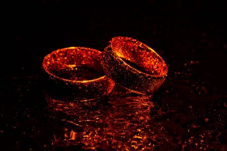 Beautiful gold wedding rings with water dropsの写真素材