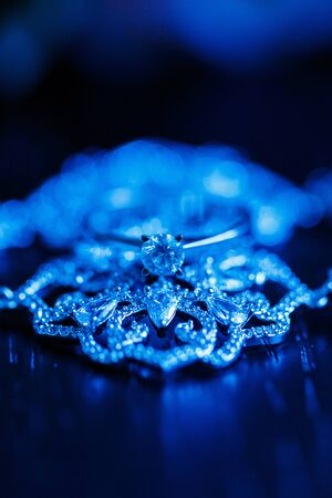 Wedding engagement ring on a dark blue neon backlight background.の写真素材
