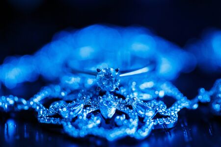 Wedding engagement ring on a dark blue neon backlight background.の写真素材