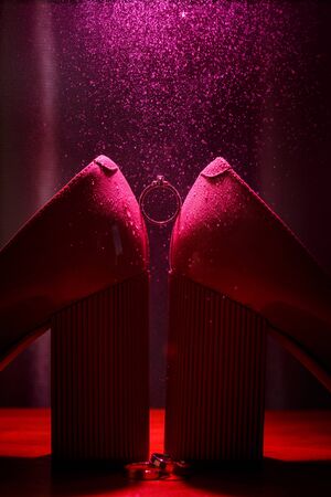 Diamond engagement ring between brides shoesの写真素材