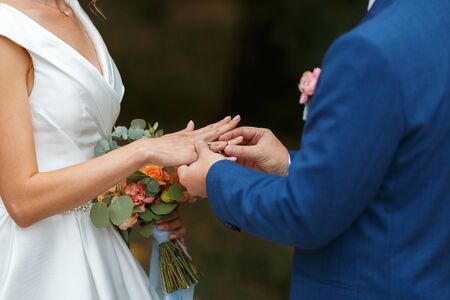 Newlyweds put each other rings on the ceremonyの写真素材