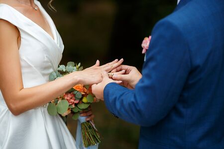 Newlyweds put each other rings on the ceremonyの写真素材