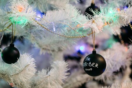 White christmas tree with black Christmas balls and decoration in barber shop.の写真素材