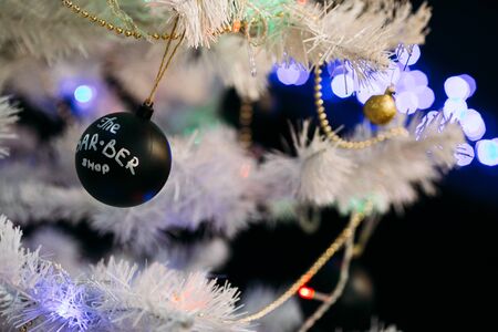 White christmas tree with black Christmas balls and decoration in barber shop.の写真素材