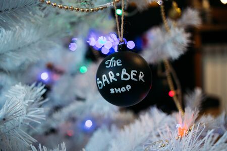 White christmas tree with black Christmas balls and decoration in barber shop.の写真素材