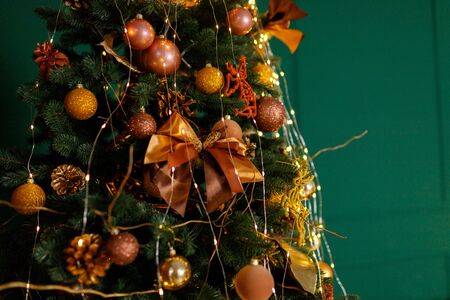 Beautiful New Year Tree decorated with colorful packed gifts and balls in studio against green background with empty place/space for Christmas text postcard concept.の写真素材
