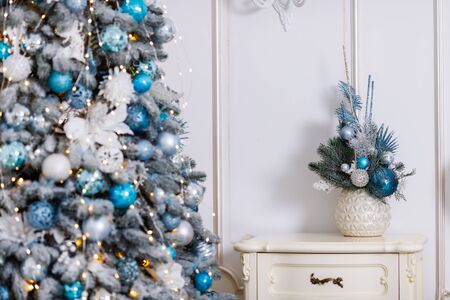 Beautiful New Year Tree decorated with colorful packed gifts and balls in studio against white background with empty place/space for Christmas text postcard concept.の写真素材
