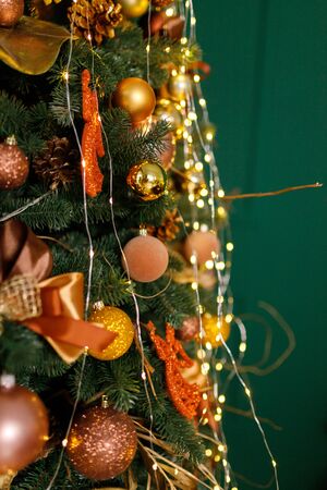 Beautiful New Year Tree decorated with colorful packed gifts and balls in studio against green background with empty place/space for Christmas text postcard concept.の写真素材