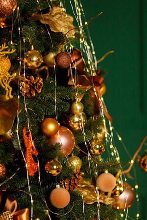 Beautiful New Year Tree decorated with colorful packed gifts and balls in studio against green background with empty place/space for Christmas text postcard concept.の写真素材