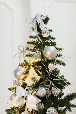 Beautiful New Year Tree decorated with colorful packed gifts and balls in studio against white background with empty place/space for Christmas text postcard concept.の写真素材