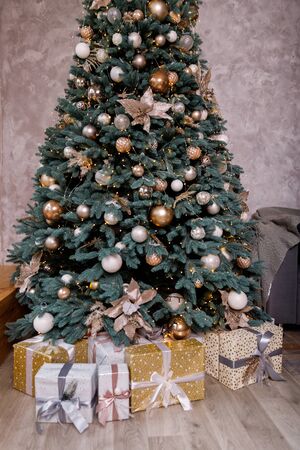 Christmas tree in the room decorated with toys and lay next to the gifts in boxesの写真素材