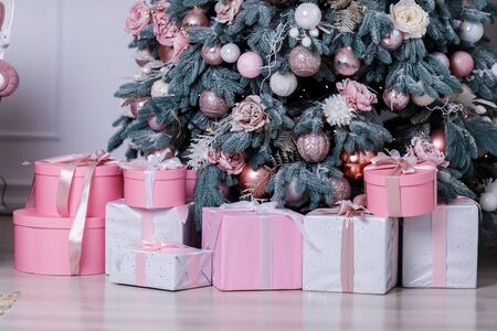 Christmas tree in the room decorated with toys and lay next to the gifts in boxesの写真素材