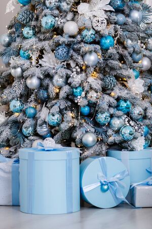 Christmas tree in the room decorated with toys and lay next to the gifts in boxesの写真素材