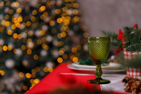 A decorated christmas dining table with champagne glasses and christmas tree in backgroundの写真素材