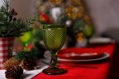 A decorated christmas dining table with champagne glasses and christmas tree in backgroundの写真素材