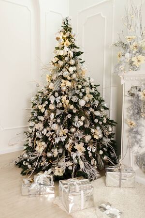 Christmas tree in the room decorated with toys and lay next to the gifts in boxesの写真素材