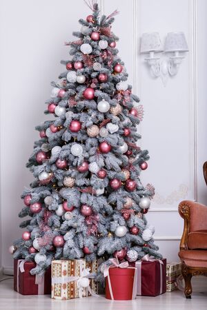 Beautiful Christmas tree decorated with toys and gift boxesの写真素材