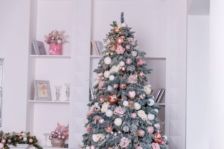 Christmas tree in the room decorated with toys and lay next to the gifts in boxesの写真素材