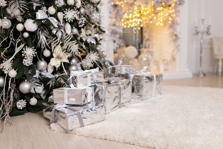 Christmas tree in the room decorated with toys and lay next to the gifts in boxesの写真素材