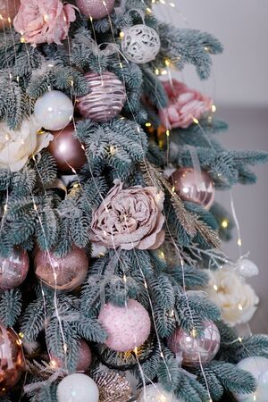 Beautiful New Year Tree decorated with colorful packed gifts and balls in studio against white background with empty space for Christmas text postcard concept.の写真素材