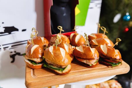 Small chicken burgers served on wooden chopping boardの写真素材