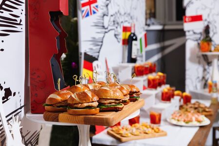 Small chicken burgers served on wooden chopping boardの写真素材