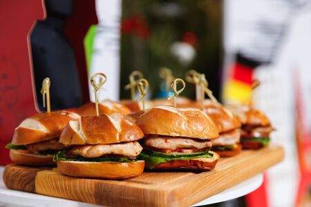 Small chicken burgers served on wooden chopping boardの写真素材