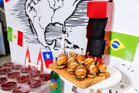 Small chicken burgers served on wooden chopping boardの写真素材